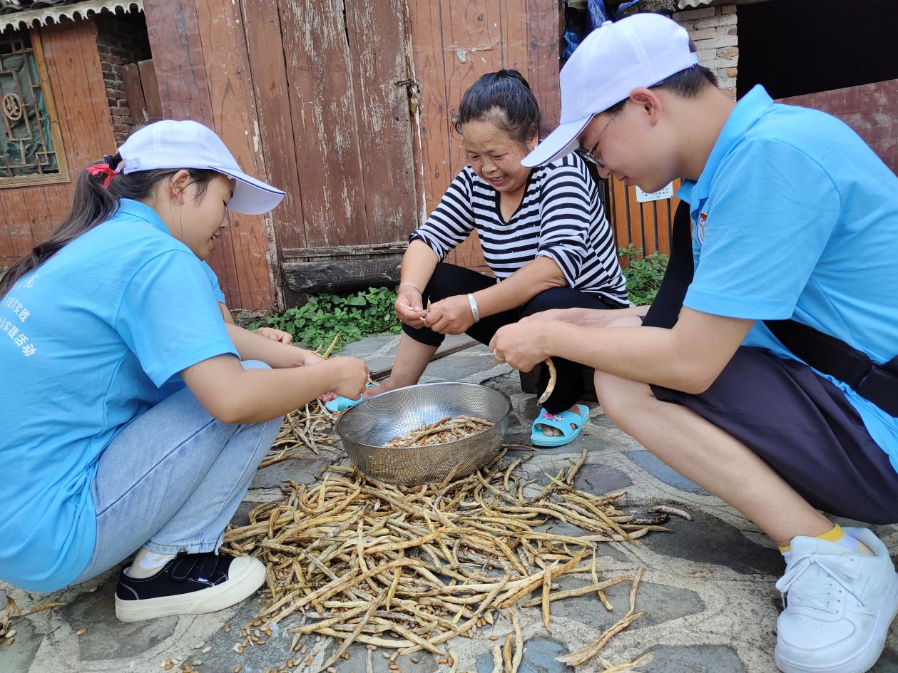 实践队员为当地居民剥豆子